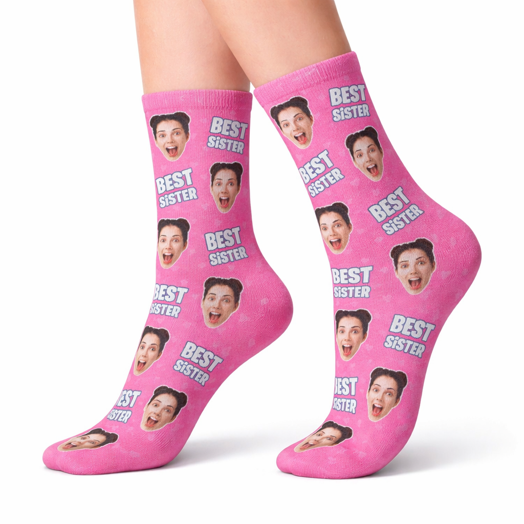 Pink socks with 'Best Sister' text and multiple faces on a white background