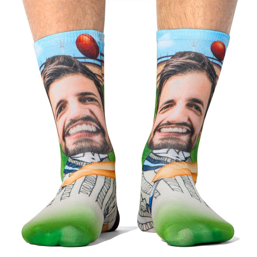 Colorful socks with a graphic design of a man's face and a green sole on a white background