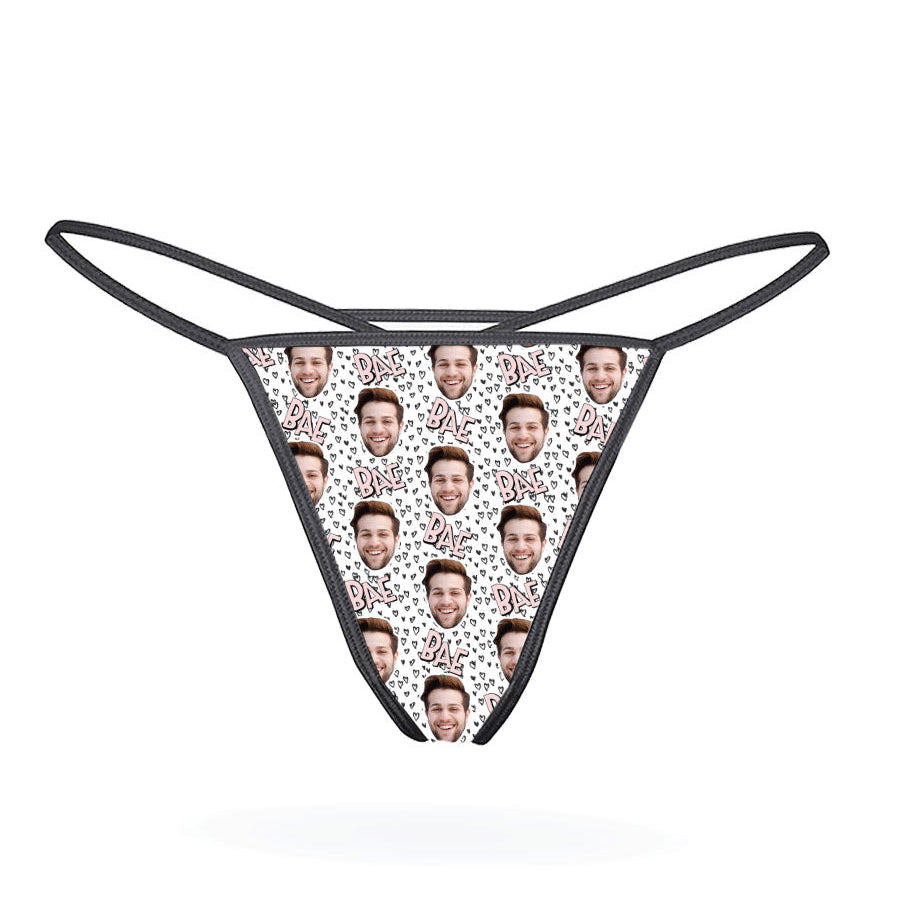 This image displays the "Bae Custom Thong," a personalized lingerie piece designed for a unique and intimate gift. The thong features a playful pattern of cartoonish faces, set against a vibrant multicolored background, adding a fun and whimsical touch.