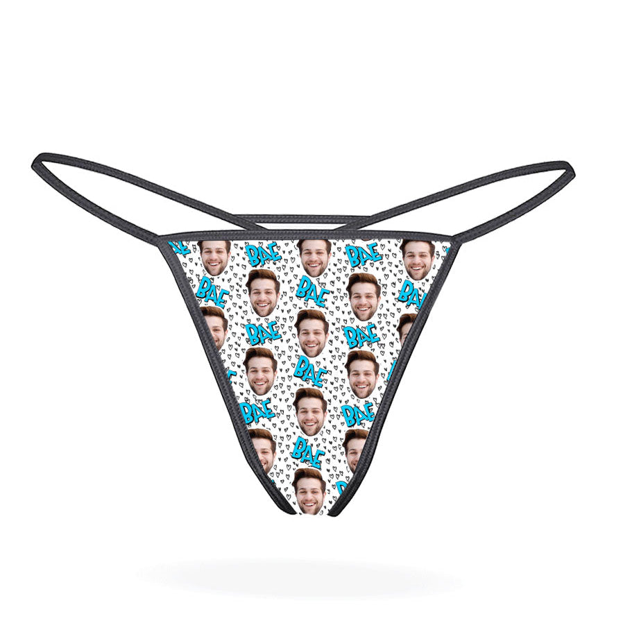 This image displays the "Bae Custom Thong," a personalized lingerie piece designed for a unique and intimate gift. The thong features a playful pattern of cartoonish faces, set against a vibrant multicolored background, adding a fun and whimsical touch.