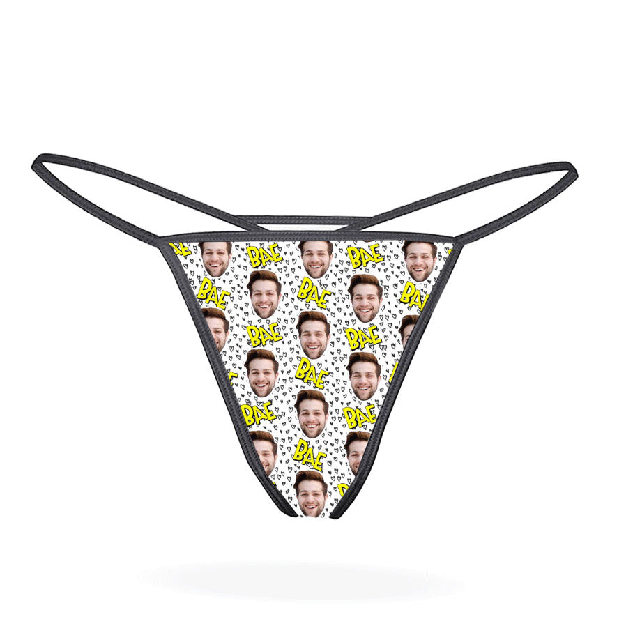 This image displays the "Bae Custom Thong," a personalized lingerie piece designed for a unique and intimate gift. The thong features a playful pattern of cartoonish faces, set against a vibrant multicolored background, adding a fun and whimsical touch.