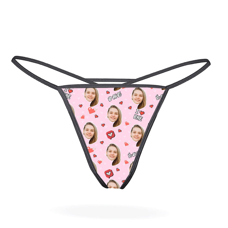 This image features a custom thong designed with a vibrant, personalized print. The thong has a bright yellow background adorned with multiple cartoonish faces in various expressions, creating a playful and eye-catching look.