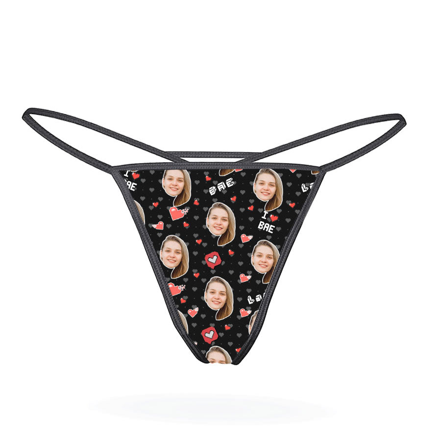 This image features a custom thong designed with a vibrant, personalized print. The thong has a bright yellow background adorned with multiple cartoonish faces in various expressions, creating a playful and eye-catching look.