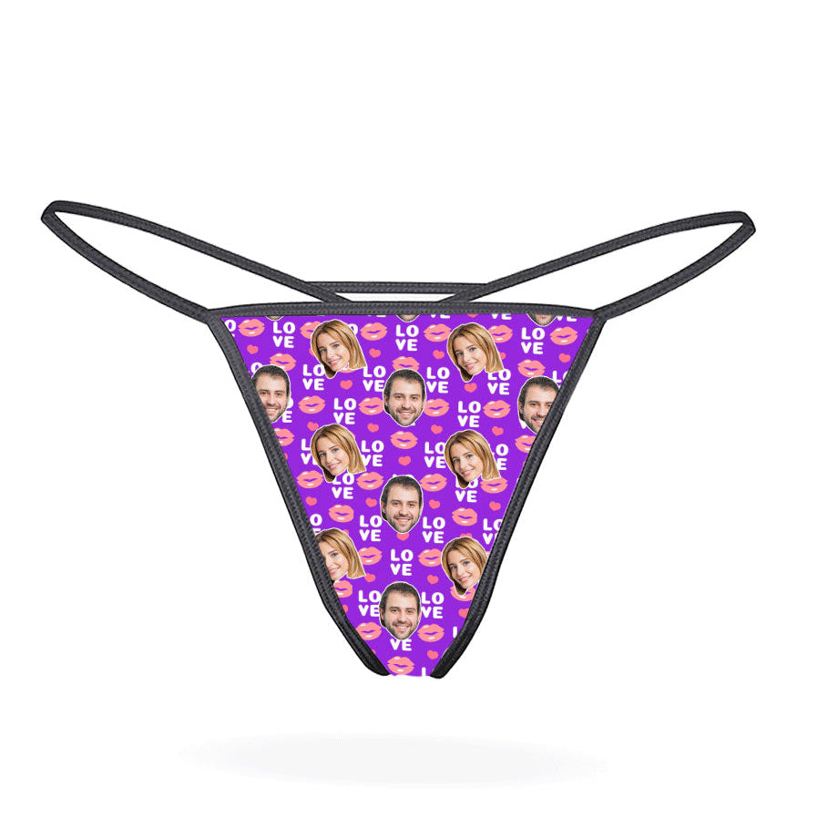 This image displays the "Love Lips Custom Thong," a playful and customizable piece of lingerie. The thong features a vibrant purple design covered with a repeated pattern of the phrase "I love you" in a stylized font, accompanied by lips and hearts motifs.