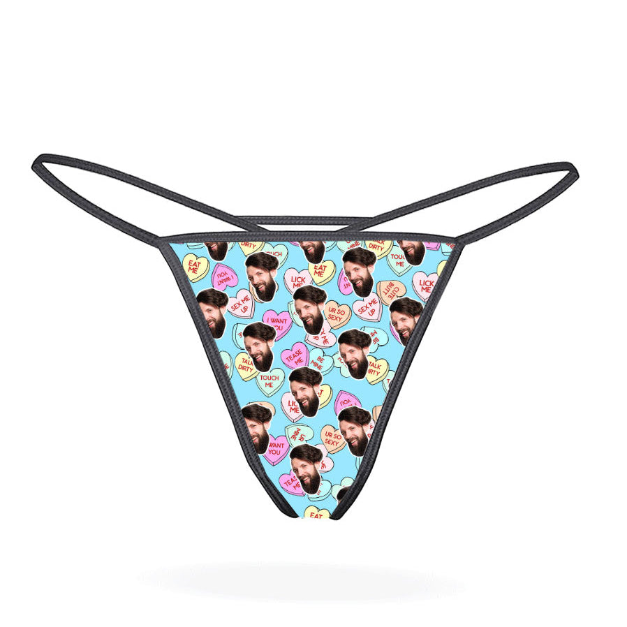 A black thong with a printed love hearts pattern in a multicolored design.