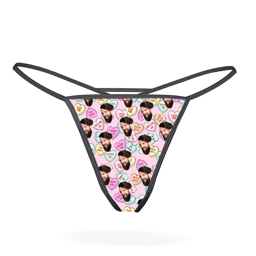 A black thong with a printed love hearts pattern in a multicolored design.