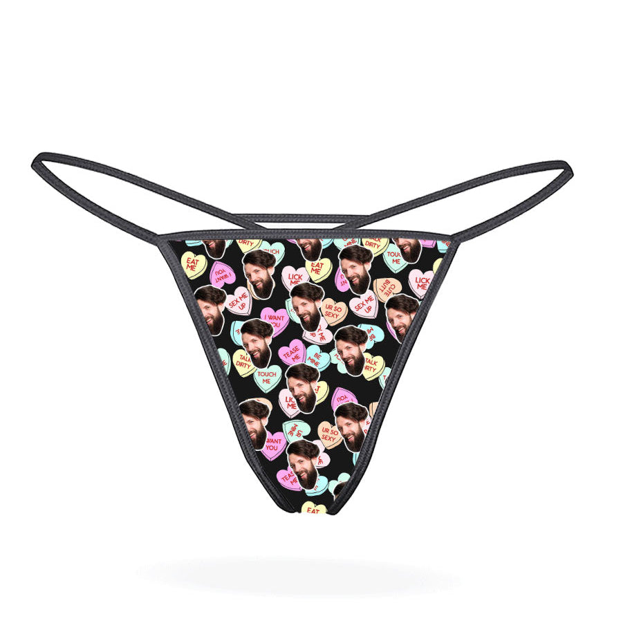 A black thong with a printed love hearts pattern in a multicolored design.