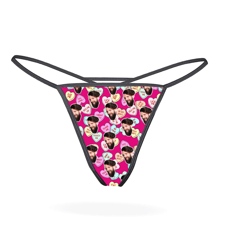 A black thong with a printed love hearts pattern in a multicolored design.