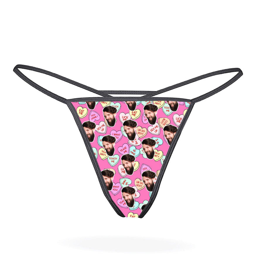 A black thong with a printed love hearts pattern in a multicolored design.