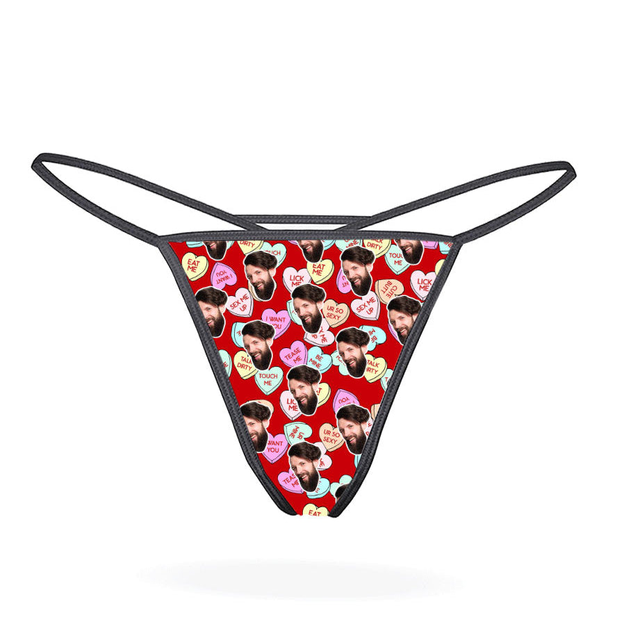 A black thong with a printed love hearts pattern in a multicolored design.