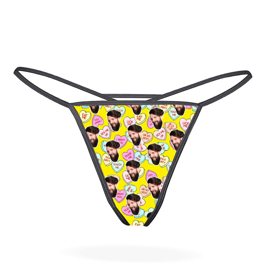 A black thong with a printed love hearts pattern in a multicolored design.