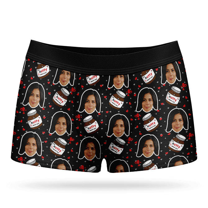 A pair of blue custom boxer shorts with a repeated pattern of a person's face and text, presumably a name, along with nuts and ice cream motifs.