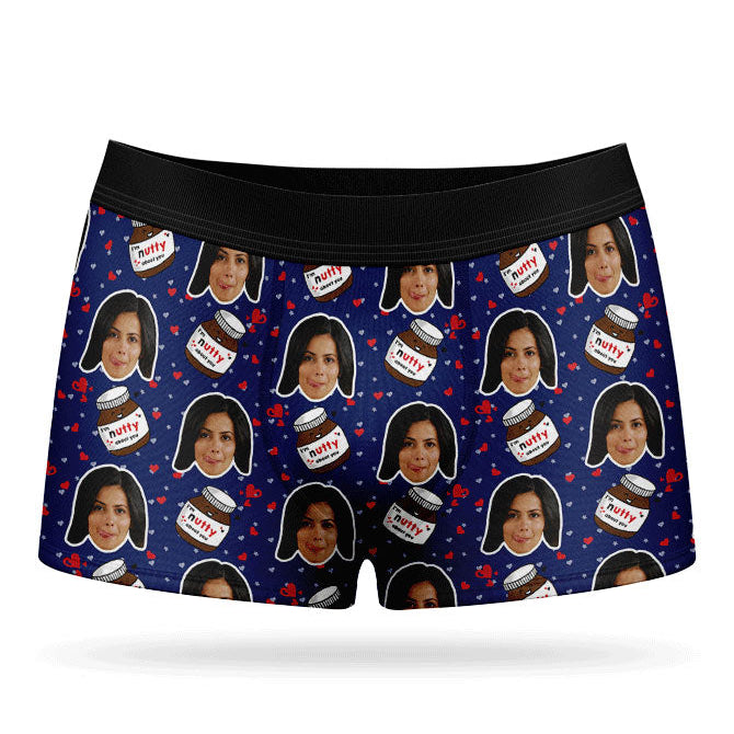 A pair of blue custom boxer shorts with a repeated pattern of a person's face and text, presumably a name, along with nuts and ice cream motifs.