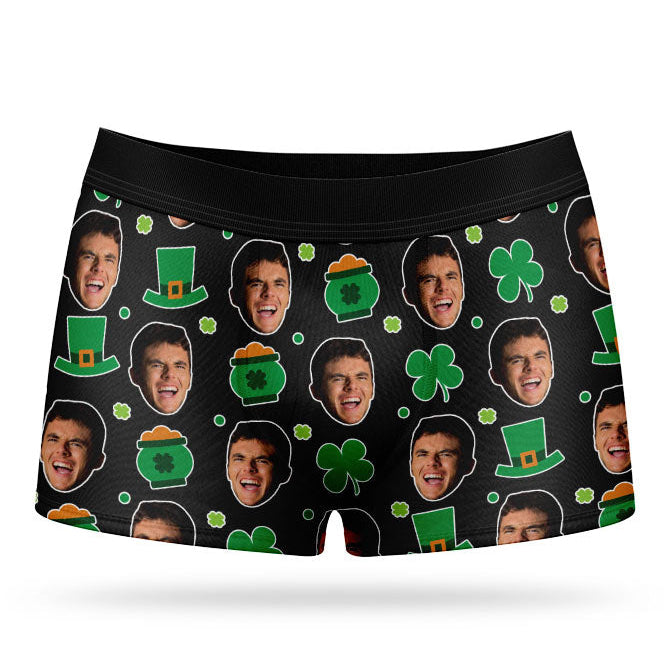A pair of green custom boxer shorts with a pattern of faces and St. Patrick's Day-themed elements, such as clovers and hats.