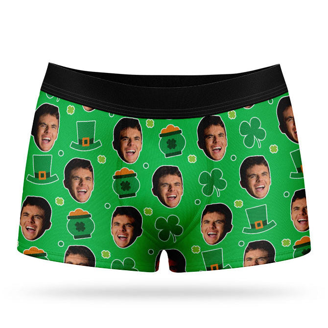 A pair of green custom boxer shorts with a pattern of faces and St. Patrick's Day-themed elements, such as clovers and hats.