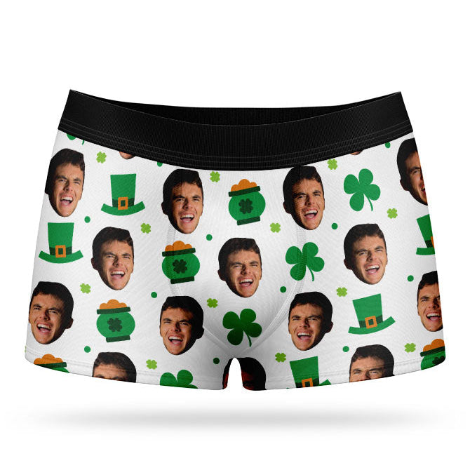 A pair of green custom boxer shorts with a pattern of faces and St. Patrick's Day-themed elements, such as clovers and hats.