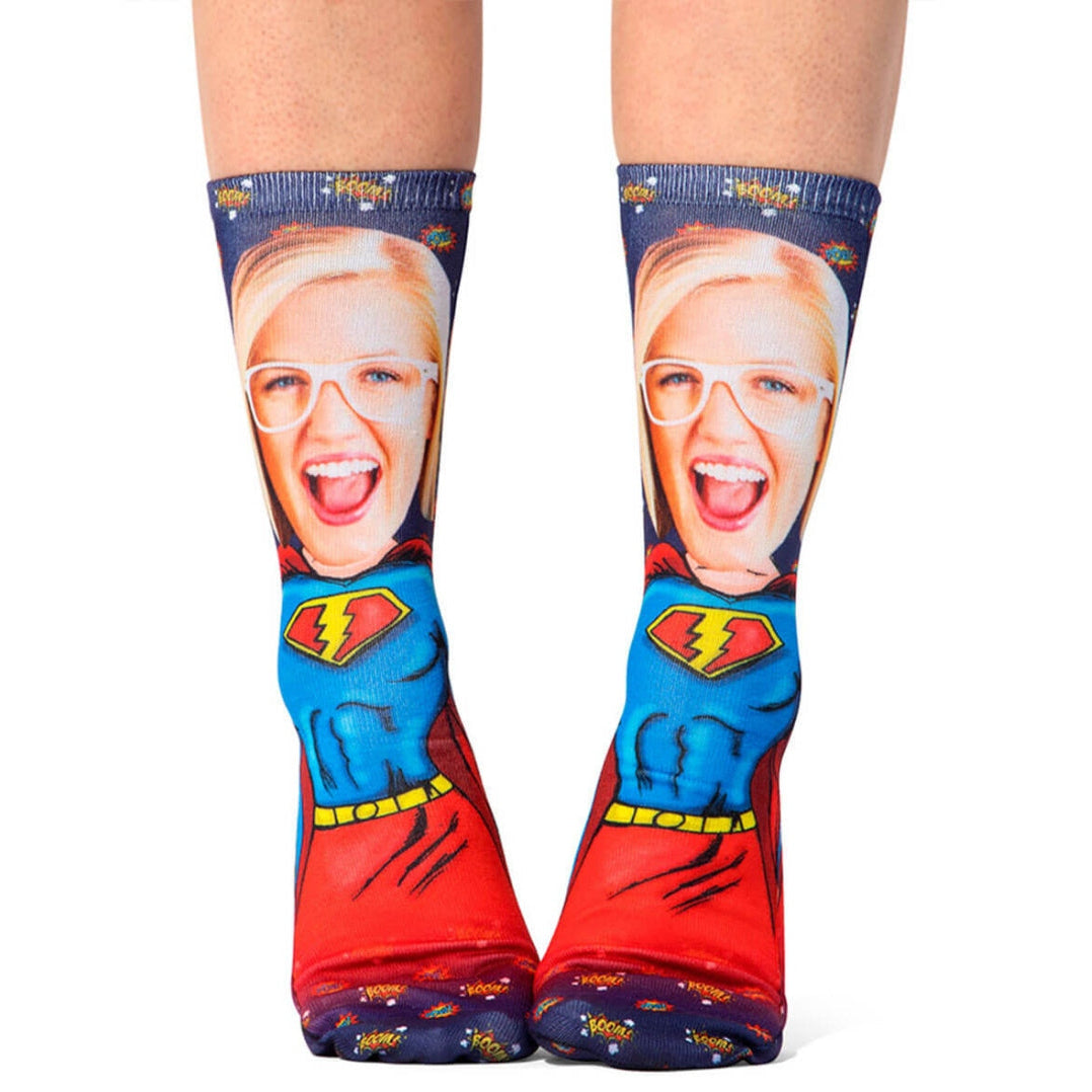 Superhero-themed socks with a face printed on the top worn by a person.