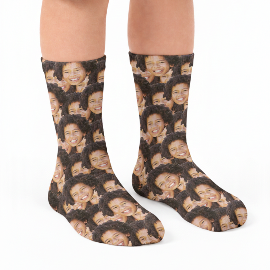 Person wearing socks with a pattern of faces on a white background