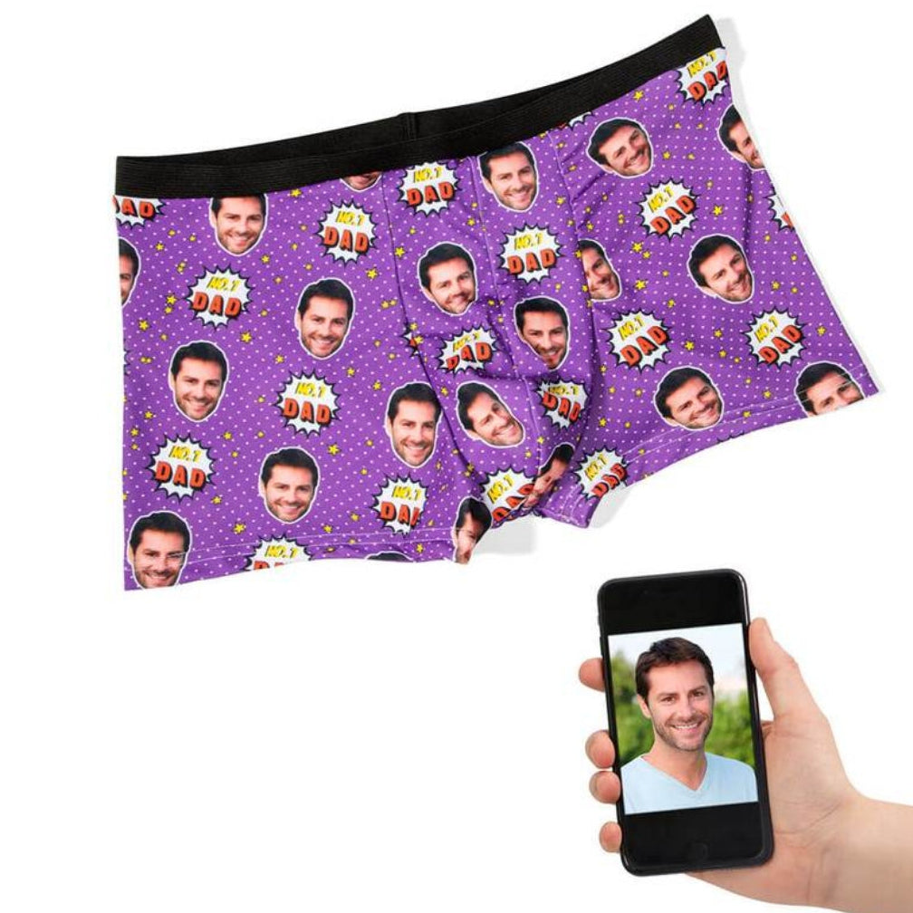 Purple underwear with personalized face pattern held by a hand using a phone.